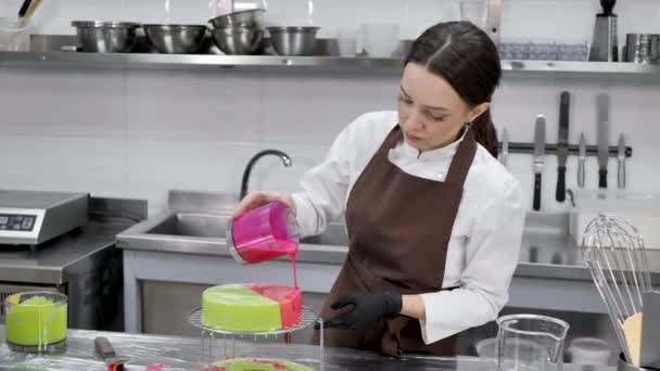 Vrouwelijk gebak chef-kok versiert een mousse cake met een spiegel glazuur — Stockvideo