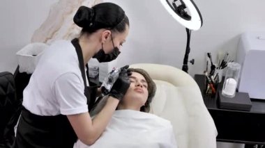 Mikro patenli kaş kavramı. Kozmetik uzmanı, kaşların kalıcı makyajını yakından yapar.