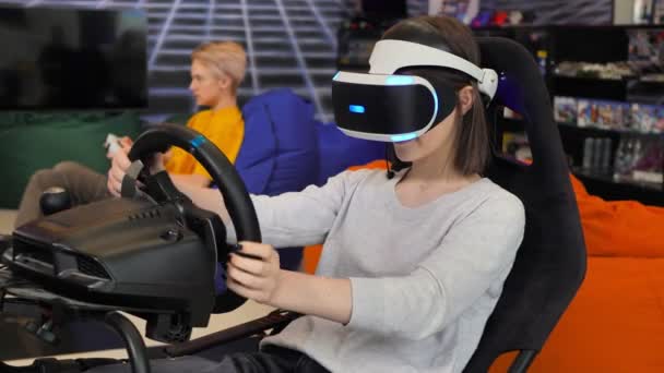 Tiener meisje dragen virtual reality bril, die houdt zich vast aan het stuur en speelt een computerspel op de console — Stockvideo