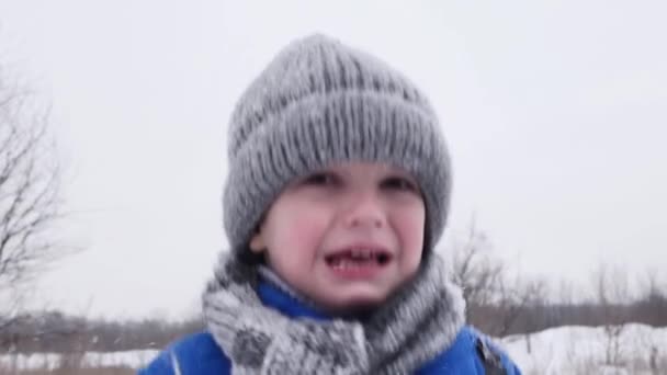 Malý chlapec v chladném pláči v zasněženém lese v zimě. Zpomalený pohyb. — Stock video