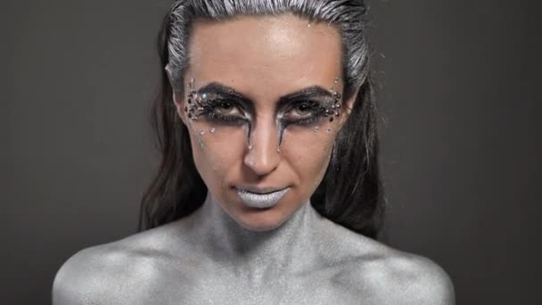 Портрет красивої жінки зі срібною фарбою на її шкірі та волоссі — стокове відео