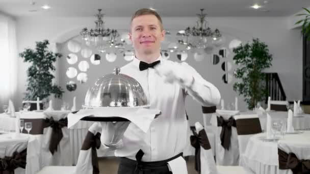 Άντρας σερβιτόρος ανοίγει το καπάκι ενός δίσκου με ένα ζεστό πιάτο — Αρχείο Βίντεο