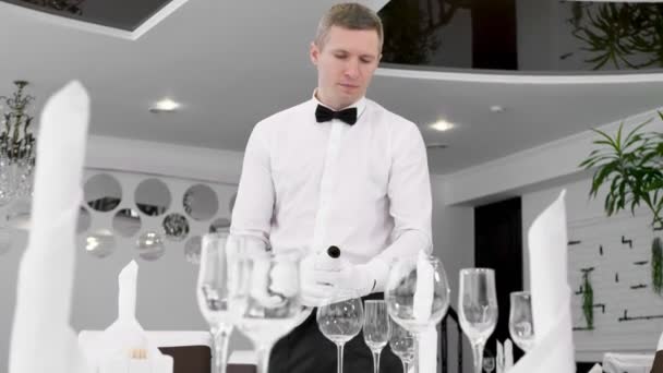 Männlicher Kellner in weißen Handschuhen gießt Rotwein ins Glas — Stockvideo