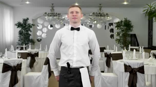 Un camarero de uniforme clásico se pone una toalla blanca en la mano. — Vídeo de stock