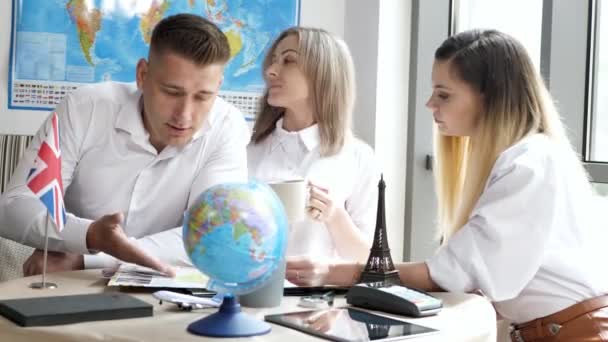 Ein Ehepaar, Mann und Frau im Büro eines Reiseveranstalters wählen einen Ort zum Reisen — Stockvideo