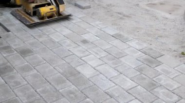 Sıkıştırma makinesi, kaldırım taşlarındaki titreşimli plakalar. Döşeme tahtaları ve kaldırım taşları konsepti