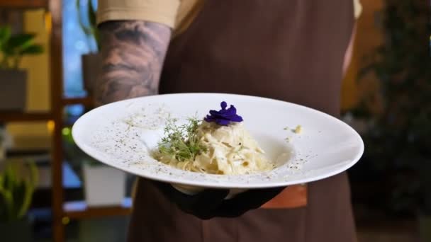 Pasta con crema y parmesano, decorada con flores comestibles y microverde de cerca — Vídeos de Stock