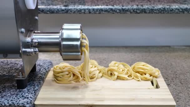 Elaboración de pasta casera italiana cruda tradicional con huevo. Espaguetis sale de la máquina de pasta — Vídeos de Stock