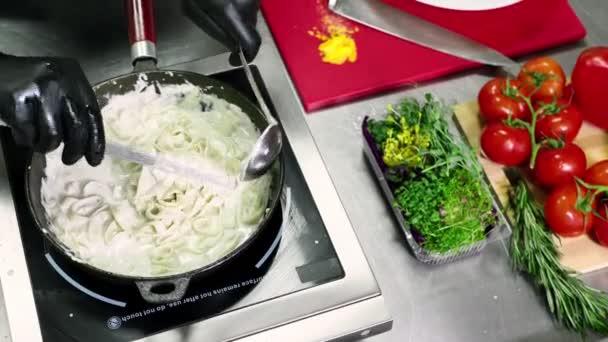 Шеф-повар намотает готовую пасту щипцами перед подачей — стоковое видео