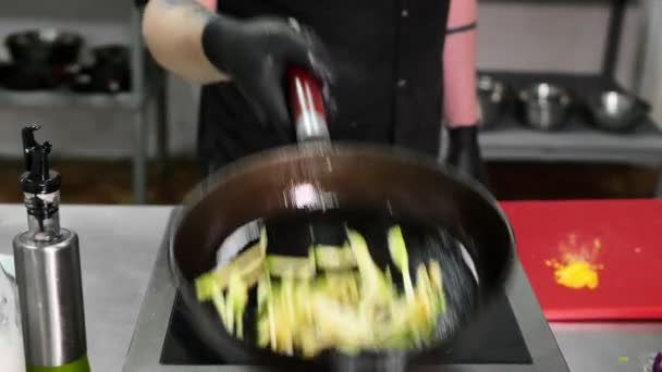 Chef in het restaurant bereidt de basis voor pasta en bak de courgette in een koekenpan — Stockvideo
