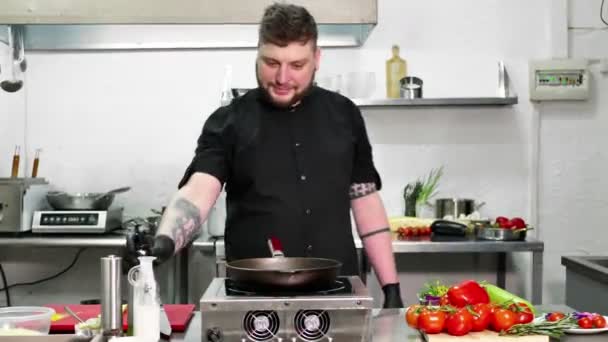Szef kuchni nalewa oliwę z oliwek do patelni, żeby zrobić makaron. — Wideo stockowe