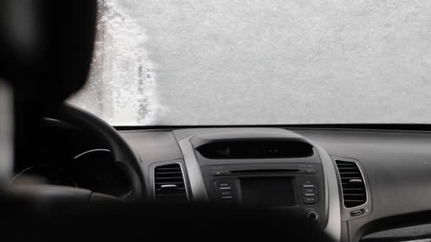 Kvinna rengör snö med vindruta med pensel Utsikt från bilens insida — Stockvideo