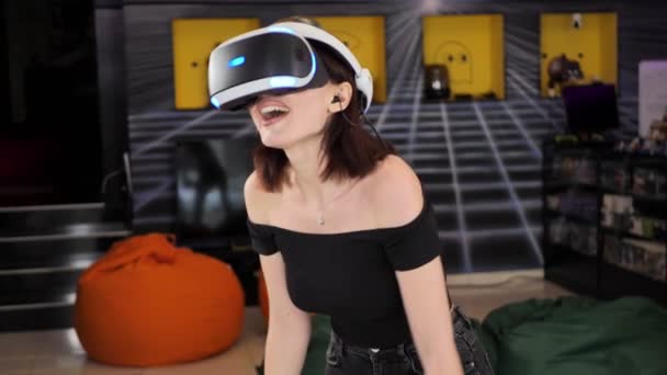 Kobieta gra na konsoli gier wideo, strzela do gry za pomocą kontrolera broni w klubie gier. VR — Wideo stockowe