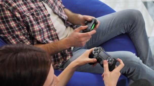 Mãos de um homem e uma mulher gostando de jogar videogames com um gamepad de console em suas mãos — Vídeo de Stock