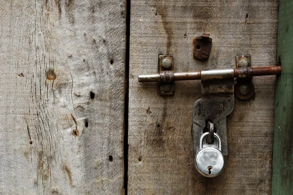 Oude houten deur en hangslot — Stockfoto