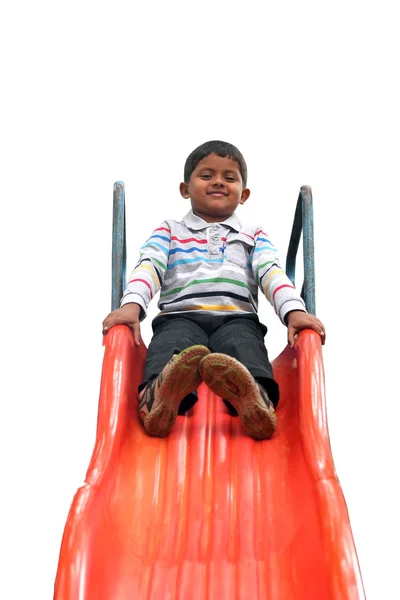 Foto aislada del chico indio guapo (niño) en el control deslizante en un parque — Foto de Stock