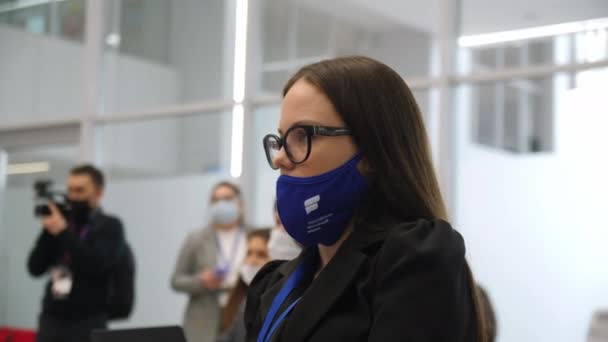 Kobieta w okularach i masce ochronnej słucha wykładu — Wideo stockowe