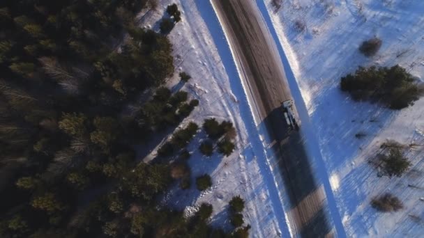 Boom chariot élévateur conduit le long de la route rurale enneigée après la forêt — Video