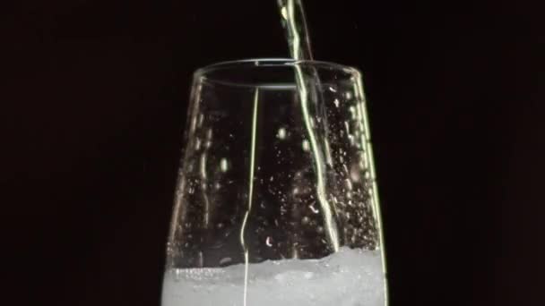Champagnewijn gieten in fluitglas staand op zwart — Stockvideo