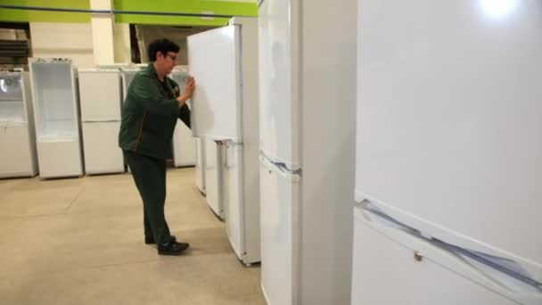 Inspecteur en vêtements de travail vérifie les nouveaux réfrigérateurs dans l'entrepôt — Video