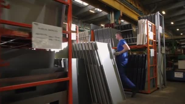 라보 르는 금속 냉장고를 운반하여 선반에 놓는다 — 비디오