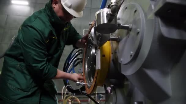Arbeiders draaien moer met moersleutel op compressor in fabriek — Stockvideo