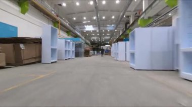 Buzdolapları ve işçilerin olduğu depo boyunca hareket