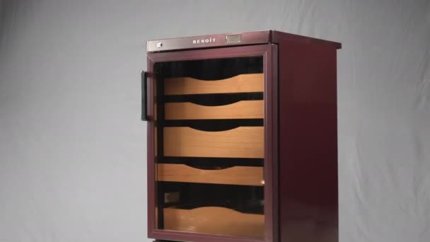 Humidor-Kühlschrank mit Glastüren dreht sich an grauer Wand — Stockvideo