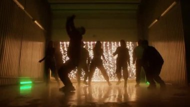 Yarı karanlık odada takla atan bir adamın silueti.