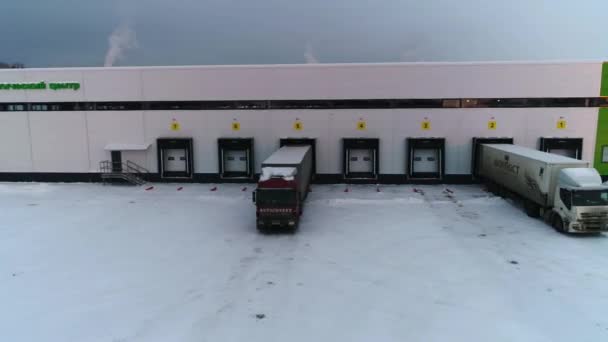 큰 트럭들은 겨울에 창고를 드나드는 모습으로 서 있다 — 비디오