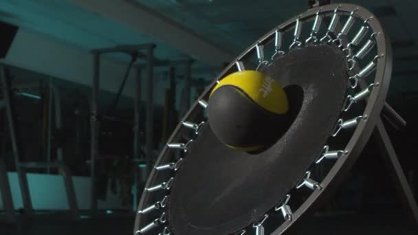 田径运动员将球抛向体育馆里的小蹦床 — 图库视频影像