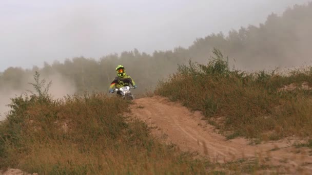 Motocross participante monta motocicleta em terreno selvagem — Vídeo de Stock