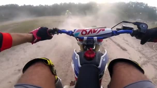 Erkek yarışçı kırsal yolda toz bulutu içinde motosiklet sürüyor. — Stok video