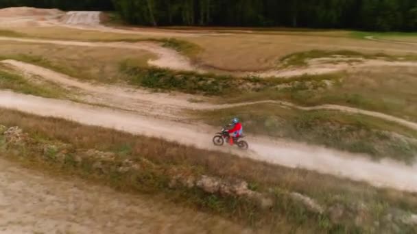 Człowiek jeździ motocyklem wzdłuż zakurzonej drogi wiejskiej w rajdzie samochodowym — Wideo stockowe