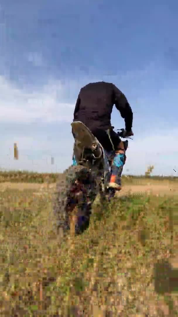 Racer passeios de moto ao longo da grama campo tomando em rali — Vídeo de Stock