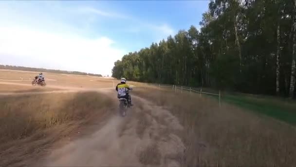 Motociclista passeios de transporte ao longo da estrada rural passado madeira — Vídeo de Stock