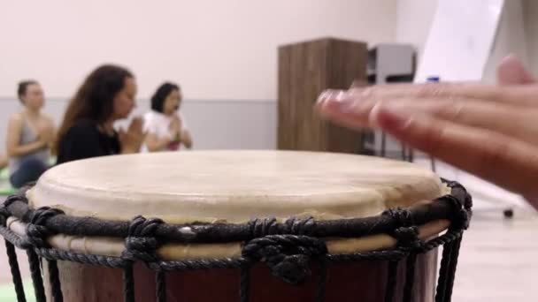 Женщина играет на небольших практикующих йогу барабанов медитировать в зале — стоковое видео