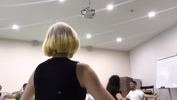 Wanita bertepuk tangan di atas kepala mengikuti instruktur di gym — Stok Video