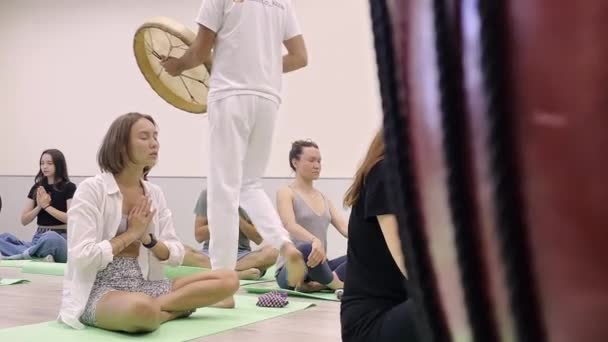 Grupp av människor mediterar instruktör spelar tamburin — Stockvideo