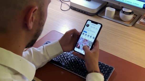 Мужчина пользуется социальными сетями на мобильном телефоне, отдыхая в офисе — стоковое видео