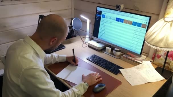 Üzletember ír papírlapon számítógép közelében CRM app — Stock videók