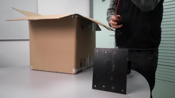 Ingeniero saca cables y cámara de la caja puesta en la mesa — Vídeos de Stock