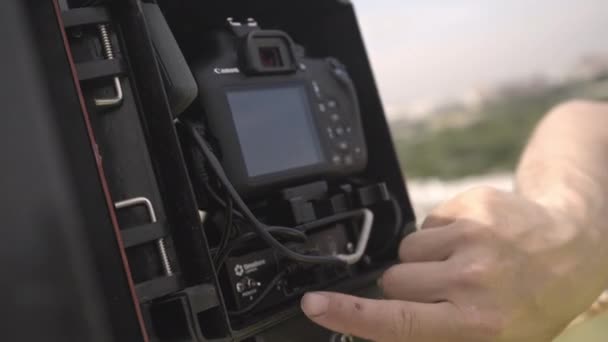 Worker takes hard disk drive from camera in casing on roof — Stock Video