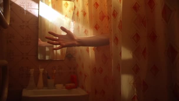 Férfi fogja a kezét a napsugár alatt áll a zuhanyfüggöny mögött — Stock videók