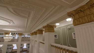 Stylish column and large glowing chandelier in theater hall