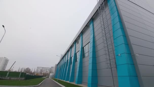 Grey and blue modern sports complex building near courts — Stockvideo