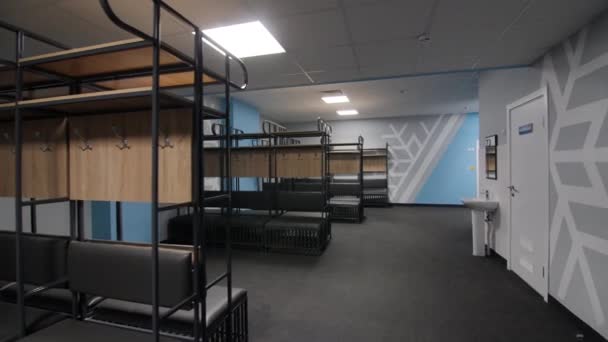 Benches with wooden shelves in light empty locker room — Stok video
