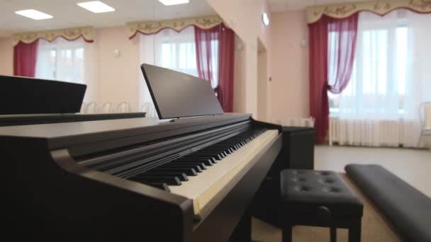 Stylish piano and stool ready for concert in bright hall — 图库视频影像