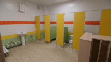 Public toilet with colorful toilet cabins showers and sinks