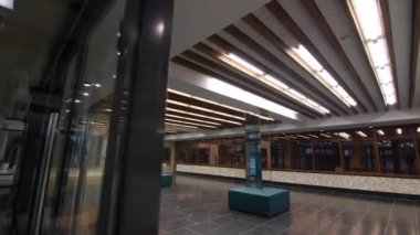 Mirrored columns with poufs in empty hall of shopping center